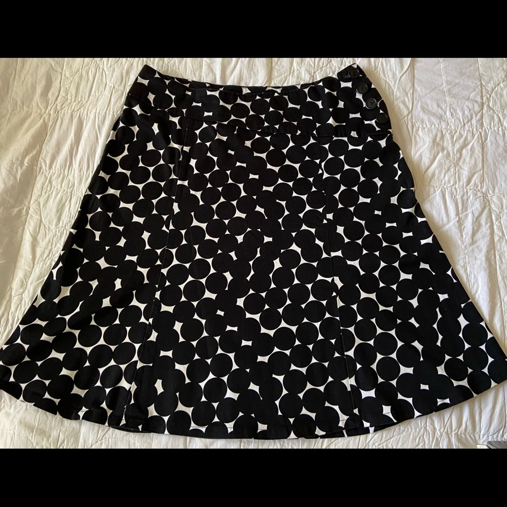 Cool black polka-dot skirt. Angled waist band with 4 black buttons.